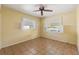 Bedroom featuring natural light from shuttered windows and tiled floors at 1115 Pennsylvania Ave, Palm Harbor, FL 34683