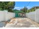 Long gated driveway lined with white walls leads to backyard buildings at 1115 Pennsylvania Ave, Palm Harbor, FL 34683