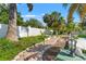 Picturesque garden pathway lined with lush greenery and swaying palm trees beneath a clear blue sky at 1115 Pennsylvania Ave, Palm Harbor, FL 34683