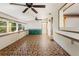 Large living room with brick-patterned tile floor and ample natural light at 1115 Pennsylvania Ave, Palm Harbor, FL 34683