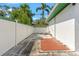 Side patio area with white fence, green trim, and tile accents providing a private outdoor space at 1115 Pennsylvania Ave, Palm Harbor, FL 34683