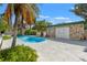 Outdoor pool with a stone pool house framed by palm trees and a sunny sky at 1115 Pennsylvania Ave, Palm Harbor, FL 34683