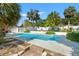 Backyard pool area featuring a refreshing in-ground pool and lush tropical landscaping at 1115 Pennsylvania Ave, Palm Harbor, FL 34683