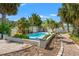 The backyard features a refreshing in-ground pool with a patio area surrounded by tropical landscaping at 1115 Pennsylvania Ave, Palm Harbor, FL 34683