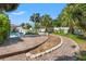 Backyard pool and patio area with a brick barbecue and lush, mature landscaping at 1115 Pennsylvania Ave, Palm Harbor, FL 34683