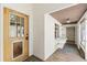 Enclosed porch entrance with wooden door, adjacent window and shelving along the side at 1115 Pennsylvania Ave, Palm Harbor, FL 34683