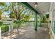 Inviting porch with wood flooring and green painted support beams at 1115 Pennsylvania Ave, Palm Harbor, FL 34683