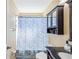 Bathroom with a vanity, blue floral shower curtain, and an overhead cabinet at 11192 Archer Ave, Spring Hill, FL 34608