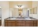 Bathroom with double sinks, marble countertops, large mirror, and a tiled floor at 11192 Archer Ave, Spring Hill, FL 34608