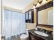 Cozy bathroom featuring a vanity with dark wood finish and granite countertop, and shower with blue patterned curtain at 11192 Archer Ave, Spring Hill, FL 34608