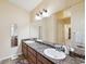 Bathroom with double sinks, marble countertops, large mirror, and a tiled floor at 11192 Archer Ave, Spring Hill, FL 34608