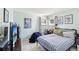 Neutral toned bedroom features a twin bed with striped bedding, multiple windows and anime themed artwork adorning the walls at 11192 Archer Ave, Spring Hill, FL 34608