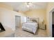 Cozy bedroom featuring a decorative headboard, ceiling fan and neutral walls with tile flooring at 11192 Archer Ave, Spring Hill, FL 34608