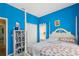 Bedroom with bright blue walls, a four-poster bed, and a bookcase at 11192 Archer Ave, Spring Hill, FL 34608