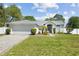 Inviting single-story home with a well-kept lawn, manicured bushes, a paved driveway, and an attached two-car garage at 11192 Archer Ave, Spring Hill, FL 34608