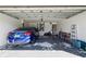 Spacious two car garage with blue sedan parked inside and plenty of storage space for tools and lawn care equipment at 11192 Archer Ave, Spring Hill, FL 34608