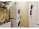 Practical laundry room with stacked washer and dryer, utility sink, and overhead shelving at 11192 Archer Ave, Spring Hill, FL 34608