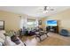 Comfortable living room with neutral colors, ceiling fan, tile floors, and ample natural light from the window at 11192 Archer Ave, Spring Hill, FL 34608