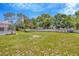 Spacious backyard with ample green space, a white fence, and a cozy fire pit area at 11291 Countrywood Ct, Spring Hill, FL 34609