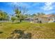 Expansive backyard featuring lush lawn, mature trees, and a screened-in pool area at 11291 Countrywood Ct, Spring Hill, FL 34609