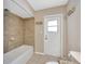 Bathroom featuring tiled shower and access door to the exterior at 11291 Countrywood Ct, Spring Hill, FL 34609