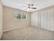 Carpeted bedroom with ceiling fan, window and closet at 11291 Countrywood Ct, Spring Hill, FL 34609