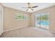 Bedroom features a ceiling fan, window, and sliding glass doors to the pool at 11291 Countrywood Ct, Spring Hill, FL 34609