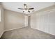 Carpeted bedroom with ceiling fan, closet and entry door at 11291 Countrywood Ct, Spring Hill, FL 34609