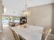 Open floor plan with dining room, chandelier, and living room in a sunlit home at 11291 Countrywood Ct, Spring Hill, FL 34609