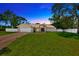 Charming single-story home featuring a manicured lawn, brick accents, and a two-car garage at 11291 Countrywood Ct, Spring Hill, FL 34609
