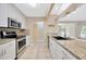 A spacious kitchen with stainless steel appliances, granite countertops, and ample lighting at 11291 Countrywood Ct, Spring Hill, FL 34609