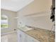 Laundry room with a sink, granite countertops, and overhead shelving at 11291 Countrywood Ct, Spring Hill, FL 34609