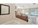 Bright and airy living room with a sectional sofa, access to the kitchen, and a view of the pool at 11291 Countrywood Ct, Spring Hill, FL 34609