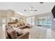 Bright living room featuring a large sectional sofa, skylight, and access to the pool area at 11291 Countrywood Ct, Spring Hill, FL 34609