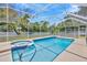 Beautiful screened-in pool area featuring a large pool, spa, and patio space at 11291 Countrywood Ct, Spring Hill, FL 34609
