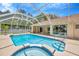 A screened-in pool and hot tub area offer outdoor enjoyment at 11291 Countrywood Ct, Spring Hill, FL 34609