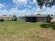 View of the house's backyard and its large screened-in back porch at 11392 Beechdale Ave, Spring Hill, FL 34608