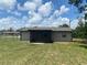 The backyard features a covered patio, a fenced yard, and mature trees at 11392 Beechdale Ave, Spring Hill, FL 34608