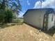 View of the home's exterior and backyard, featuring ample space, partial fencing, and mature trees at 11392 Beechdale Ave, Spring Hill, FL 34608