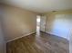 This cozy bedroom has wood-look floors, closet and neutral color scheme at 11392 Beechdale Ave, Spring Hill, FL 34608