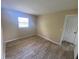 A sunny bedroom with wood-look flooring, featuring a large window and closet at 11392 Beechdale Ave, Spring Hill, FL 34608