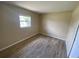 The bedroom has wood-look floors, a neutral color palette, and a window offering natural light at 11392 Beechdale Ave, Spring Hill, FL 34608