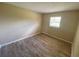 A clean bedroom featuring a window that allows for natural light and wood-look flooring at 11392 Beechdale Ave, Spring Hill, FL 34608