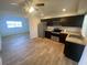 Well-lit kitchen boasts stainless steel appliances, dark wood cabinets, and durable wood-look flooring at 11392 Beechdale Ave, Spring Hill, FL 34608