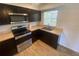 Kitchen featuring stainless steel appliances, dark wood cabinets and light counter tops at 11392 Beechdale Ave, Spring Hill, FL 34608