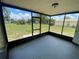 The screened porch offers an indoor/outdoor experience with epoxy flooring and views of the grassy, fenced yard at 11392 Beechdale Ave, Spring Hill, FL 34608