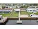 Aerial view of home with waterfront access, screened-in porch, and a backyard patio at 12637 2Nd Isle, Hudson, FL 34667