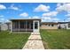 Landscaped backyard with a paved walkway leading to the house's screened lanai at 12637 2Nd Isle, Hudson, FL 34667