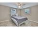 Neutral bedroom with tile floors, a ceiling fan, and two windows letting in natural light at 12637 2Nd Isle, Hudson, FL 34667