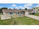 Single-story home with a brick facade, turquoise shutters, a paved driveway, and a manicured lawn at 12637 2Nd Isle, Hudson, FL 34667